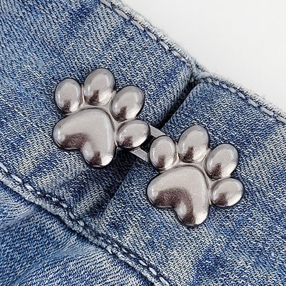 One set of gunmetal dog paw waist tightener buttons fastened on a denim jeans waistband