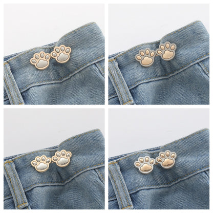 Four sets of paw waist adjusters, one in each colour, shown on denim waistbands