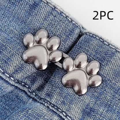 Two sets of gunmetal dog paw waist tightener buttons, one pair shown on a denim waistband, labelled 2PC