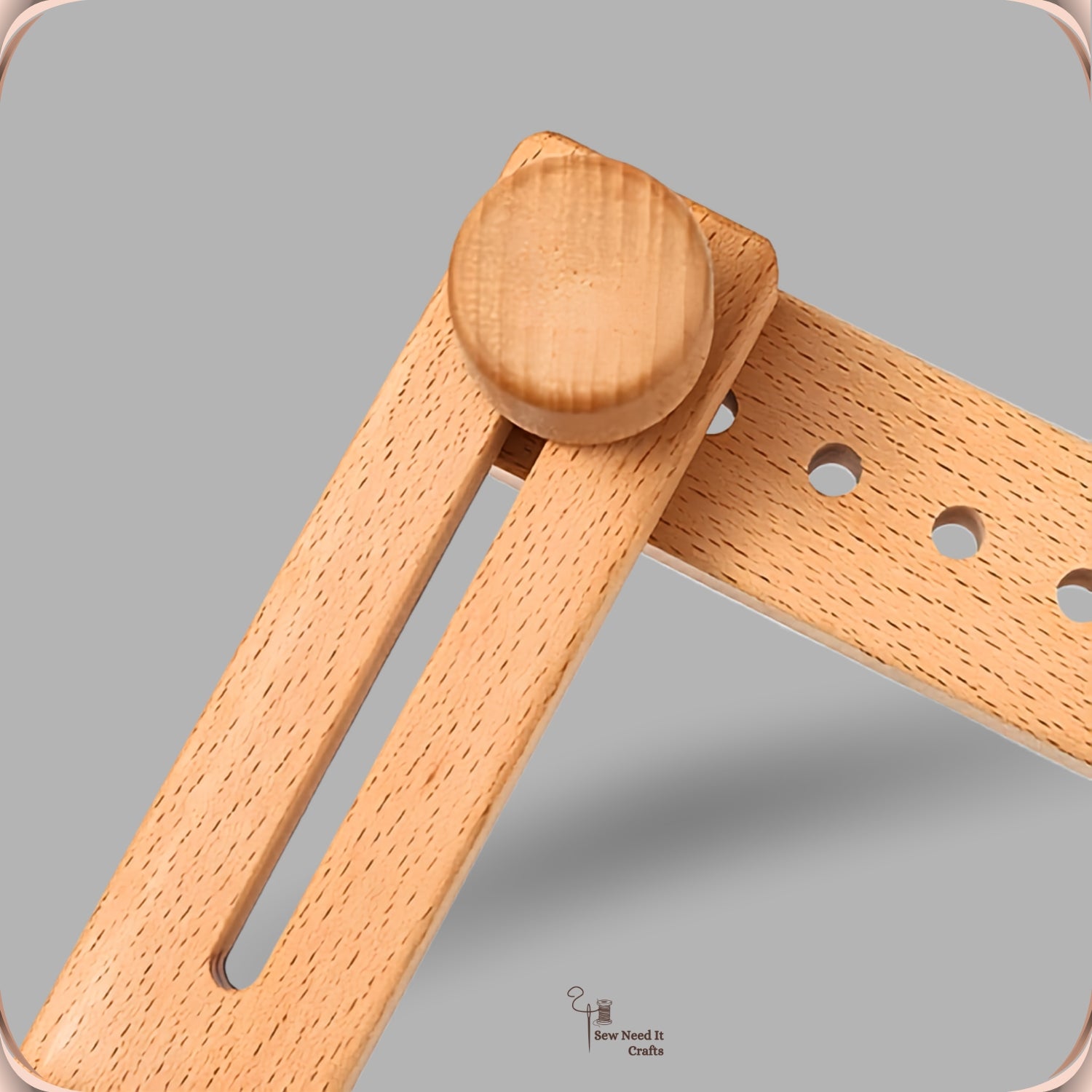 Close-up of the jointed beechwood arm of the embroidery stand, showing the wooden pivot knuckle and the slot that adjusts the arm length
