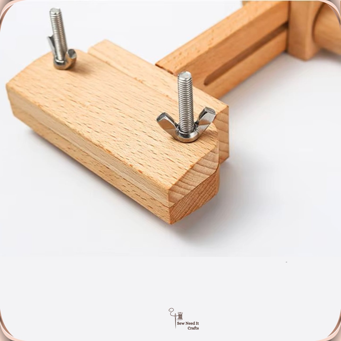 Close-up of the hoop splint on the embroidery stand, a flat beechwood bar with two metal thumb screws that clamp the hoop rim
