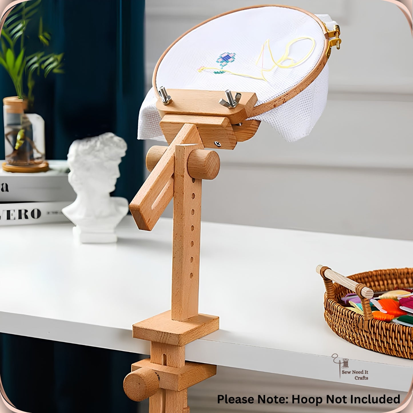 Clamp-on embroidery stand on a table edge with the hoop tilted upright for stitching, captioned Hoop Not Included