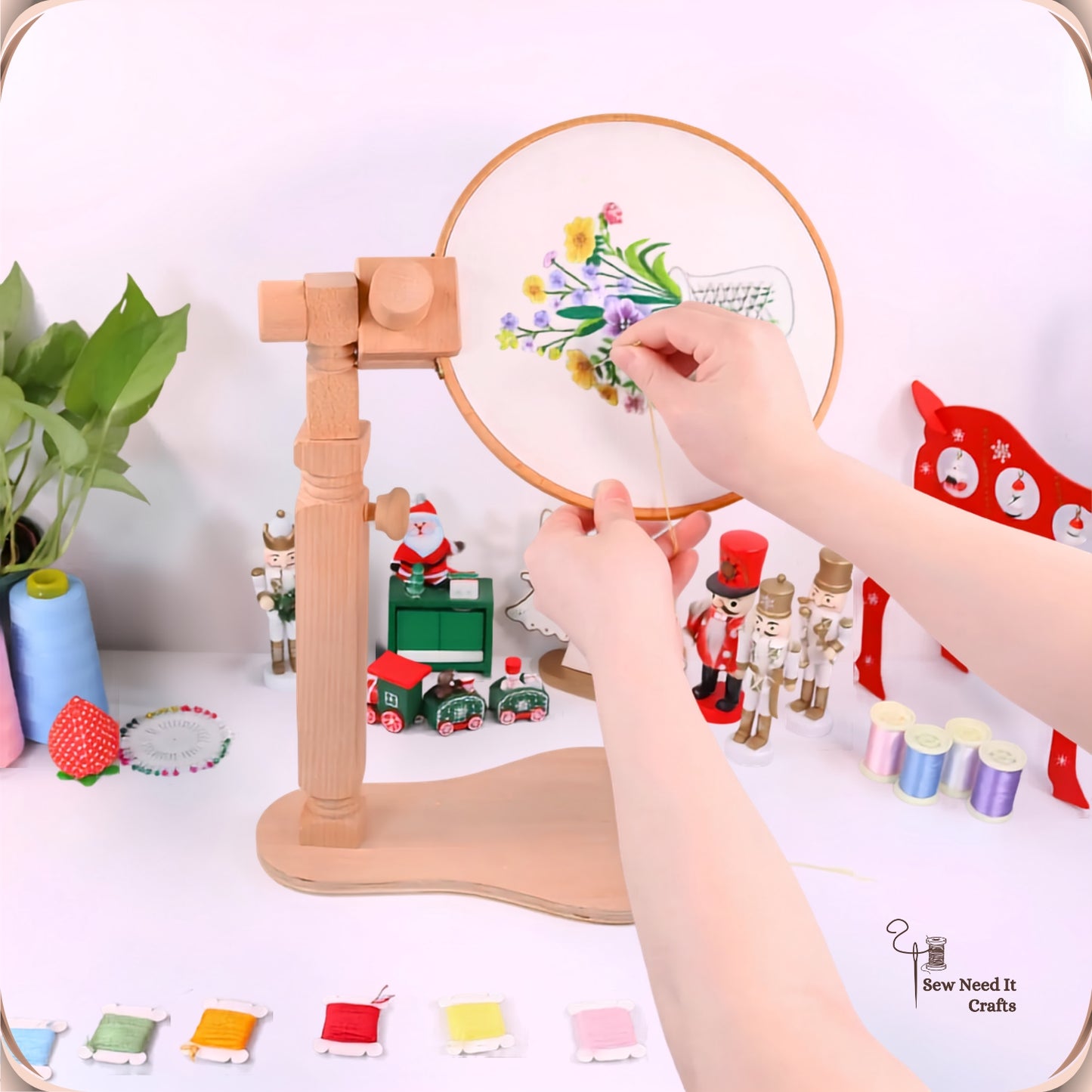 Beechwood cross stitch lap stand on a desk holding an embroidery hoop, both hands free to stitch a floral design