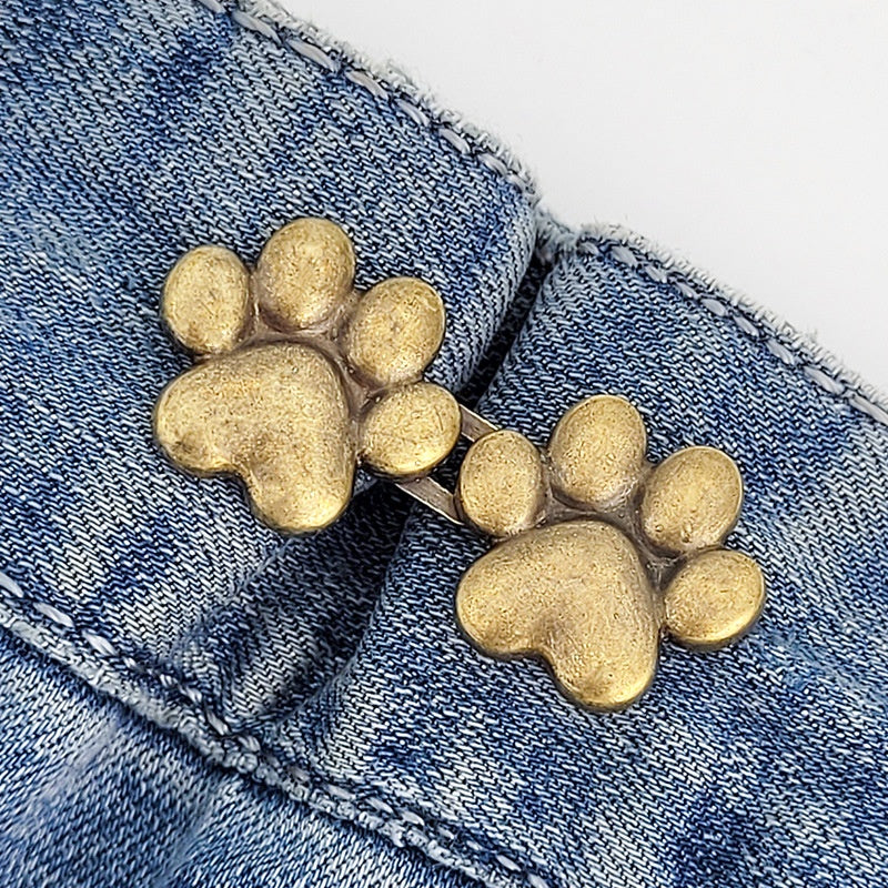 One set of bronze dog paw waist tightener buttons fastened on a denim jeans waistband