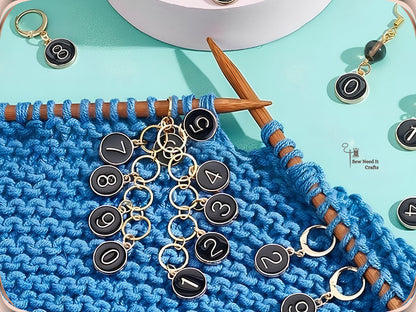 Black numbered stitch markers clipped into a blue knitting project on a bamboo needle, chained together to track rows