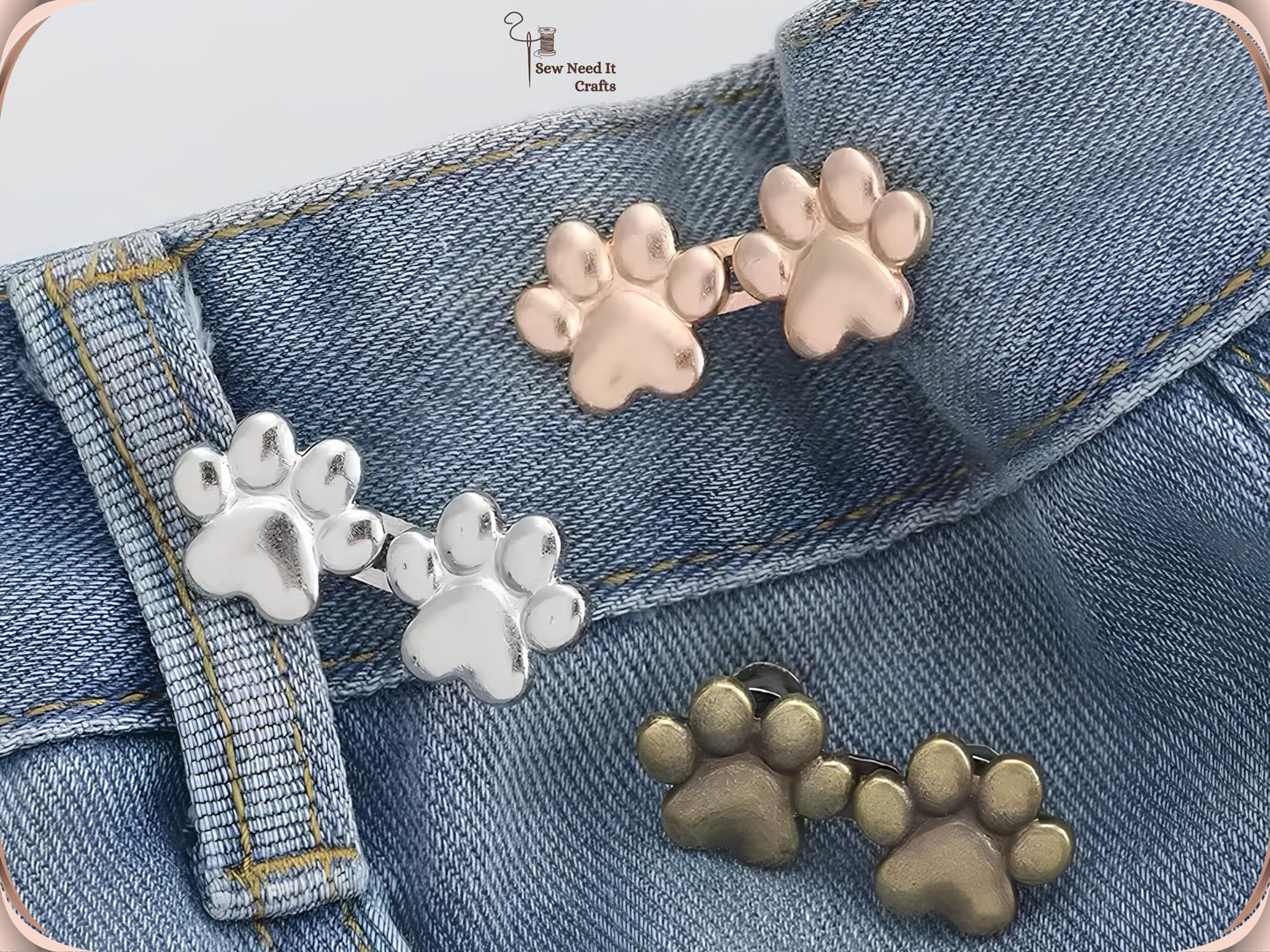 Paw waist adjuster buttons in silver, bronze, golden and gunmetal on a white dish and printed card, showing the pin posts on the reverse