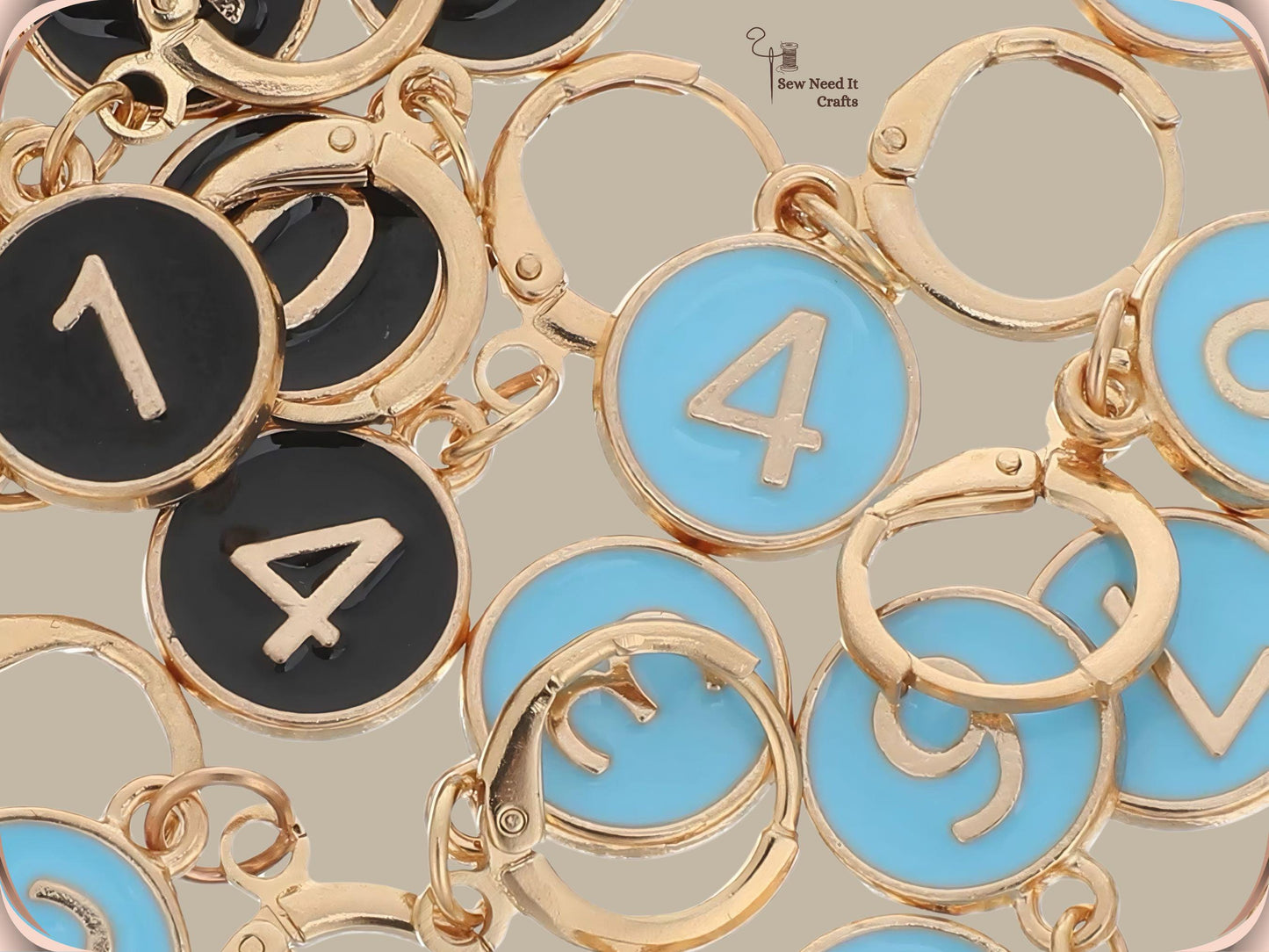 Macro close-up of black and blue enamel numbered stitch marker charms and their open gold-tone hinged hoop clasps