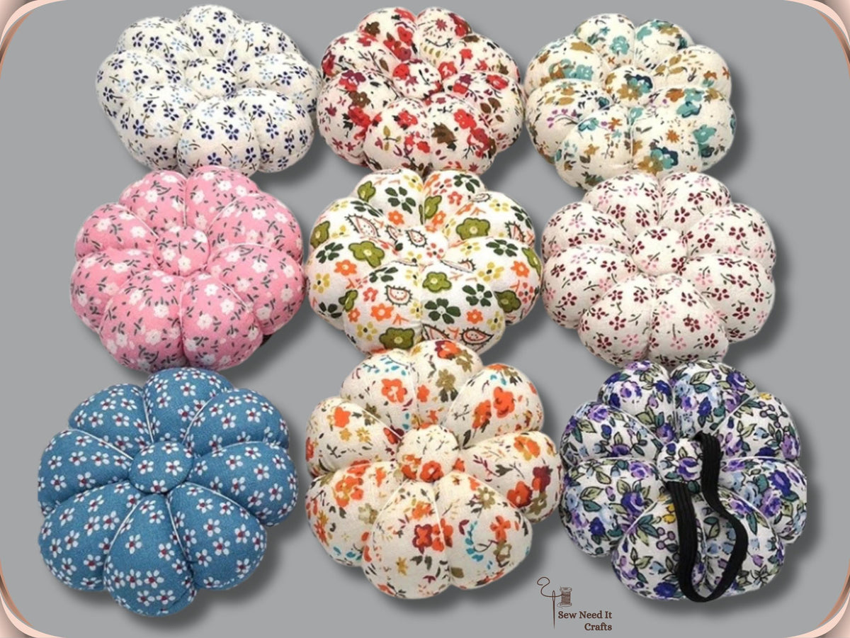 Nine fabric pumpkin wrist pin cushions in assorted floral prints with black elastic bands