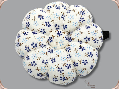 White pumpkin wrist pin cushion with navy and light blue flowers and black elastic band