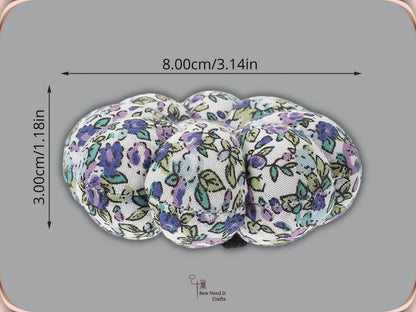 Side view of a purple floral wrist pin cushion measured at 8 cm across and 3 cm tall