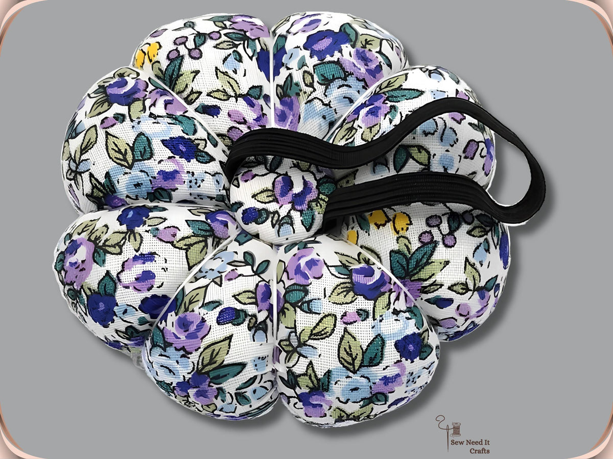 Purple Floral pumpkin wrist pin cushion turned to show the black elastic band on the underside