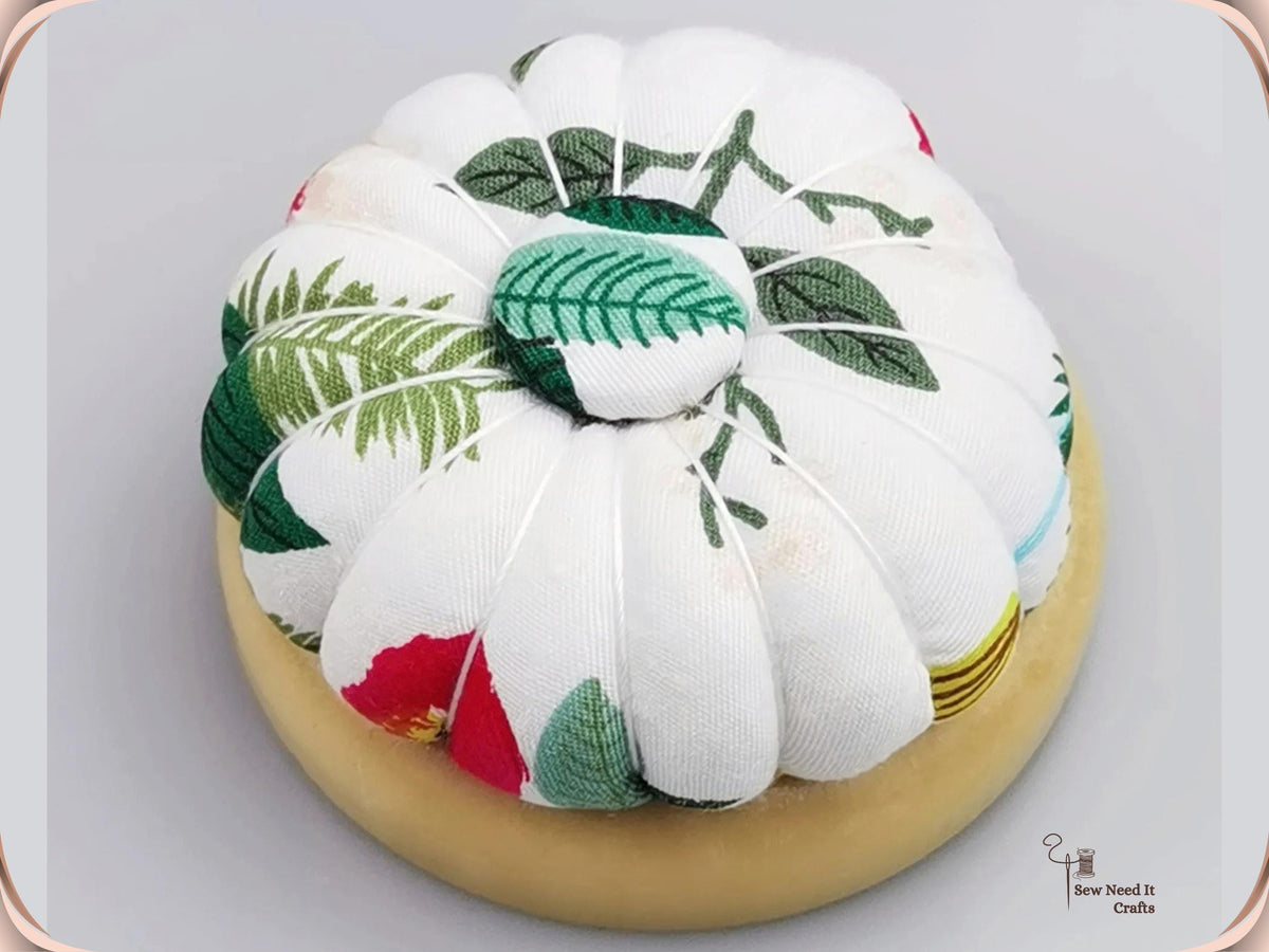 Leaf Print pumpkin pin cushion, white with green leaves, on a natural wooden base