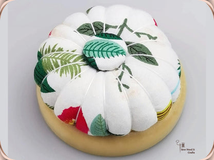 Leaf Print pumpkin pin cushion, white with green leaves, on a natural wooden base