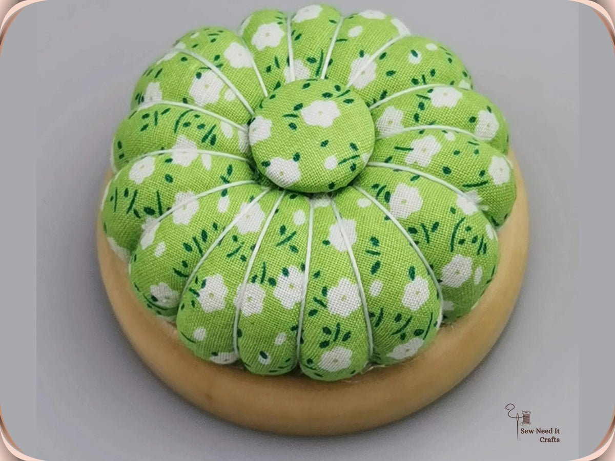 Green Floral pumpkin pin cushion with white flowers on a natural wooden base