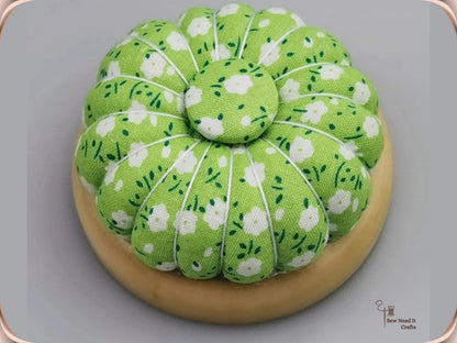 Green Floral pumpkin pin cushion with white flowers on a natural wooden base
