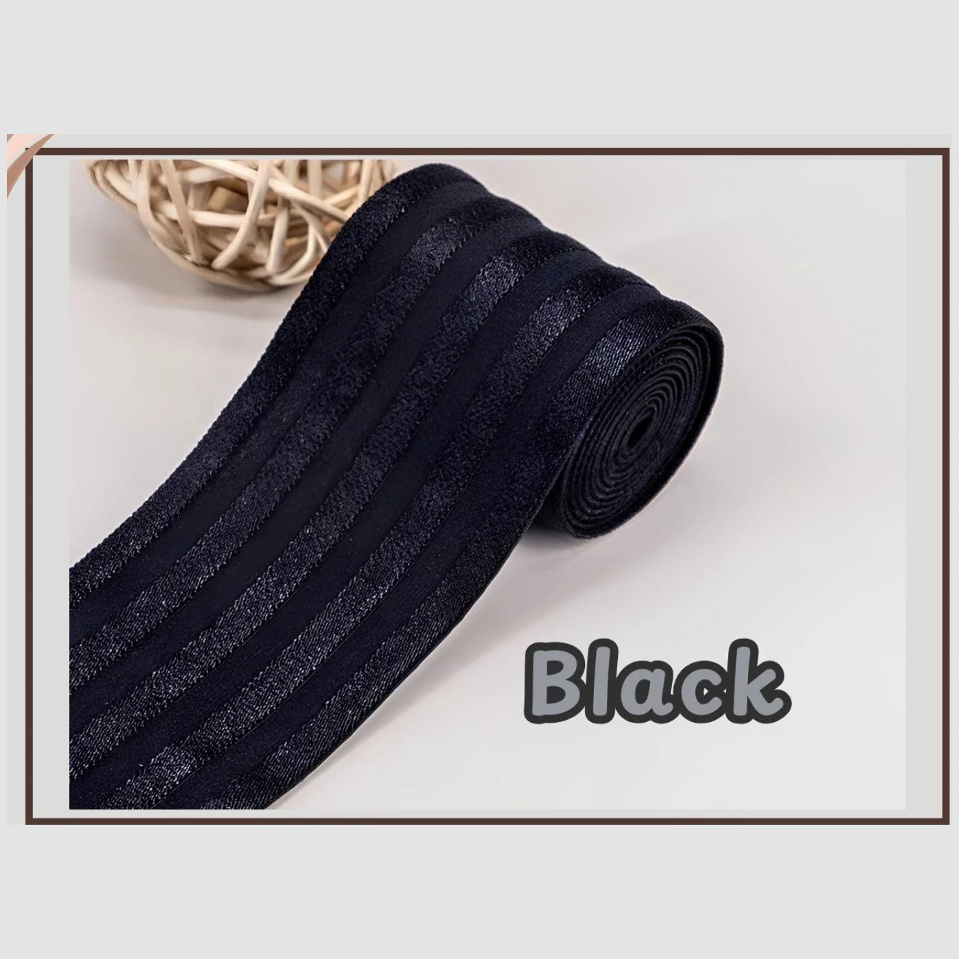 Black 2 inch satin stripe elastic band for sewing, partly rolled and labelled Black