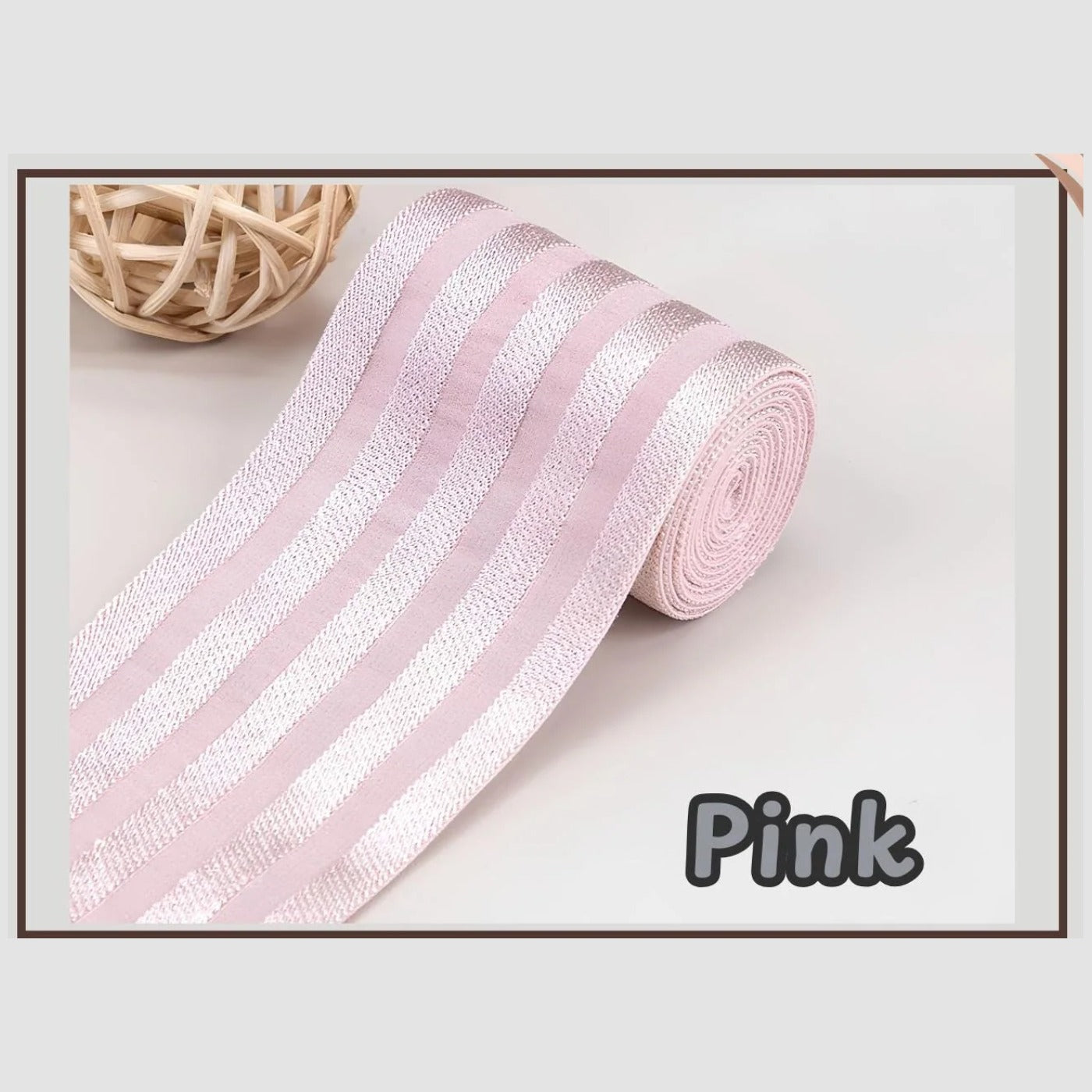 Pink 2 inch satin stripe elastic band for sewing, partly rolled and labelled Pink