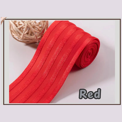 Red 2 inch satin stripe elastic band for sewing, partly rolled and labelled Red