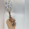 Video demonstrating the beechwood embroidery hoop stand: the hoop being unclamped and re-clamped by hand, the arm folding and extending through its height range, 360 degree rotation at the clamp and base, and the stand used as a sit-on lap stand on a chair