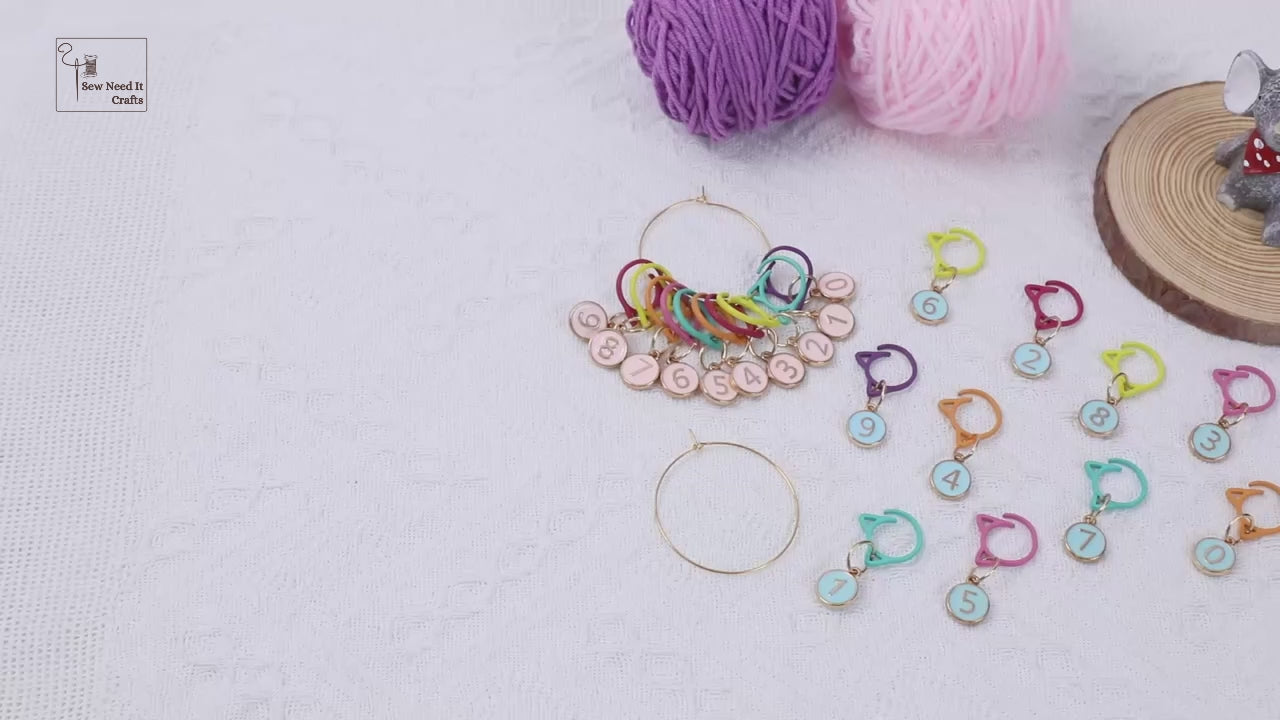 Video demonstration of the numbered cat-ear stitch markers: the full set shown on its gold-tone storage ring, then markers clipped onto a cream knitted swatch on the needles, and finally clipped into crochet worked with a hook