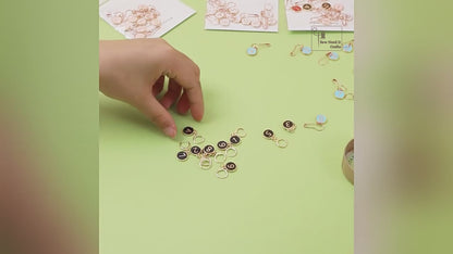 Video showing the hinged clasp opening and closing, and numbered stitch markers being clipped into a crochet project as it is worked
