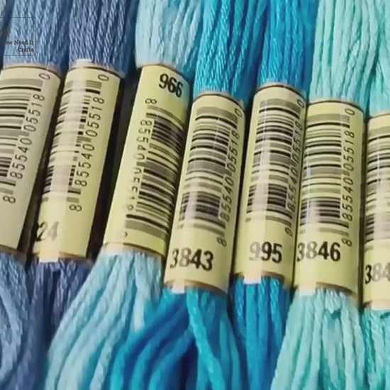 Video of banded six-strand embroidery floss skeins in blues, greys, greens and pinks, then hands holding a mixed pack and winding the floss